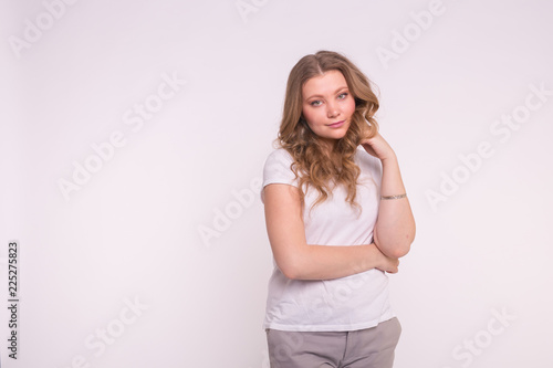 Fashion, style and people concept - pretty young woman dressed in white shirt over white background with copy space
