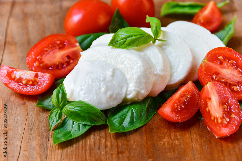ingredients for Italian Caprese salad: red tomatoes, fresh organic mozzarella and Basil, Italian cuisine