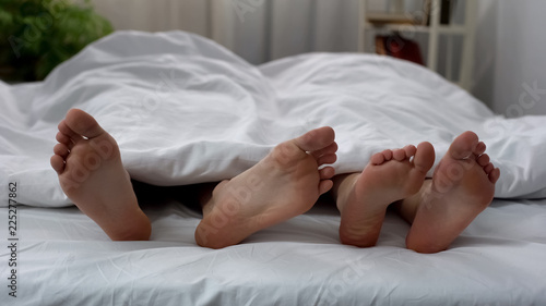 Foto Male trying to touch female with his foot, conflict and crisis in relationship