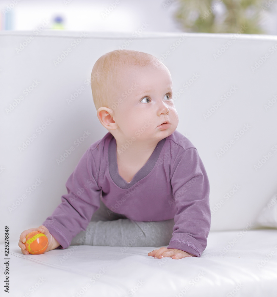 pretty baby playing with a ball on the couch pretty baby playing with a ball on the couch