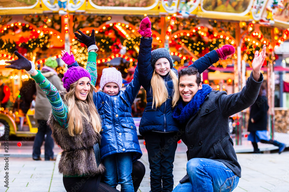 Naklejka premium Cheerful family having fun on Christmas market