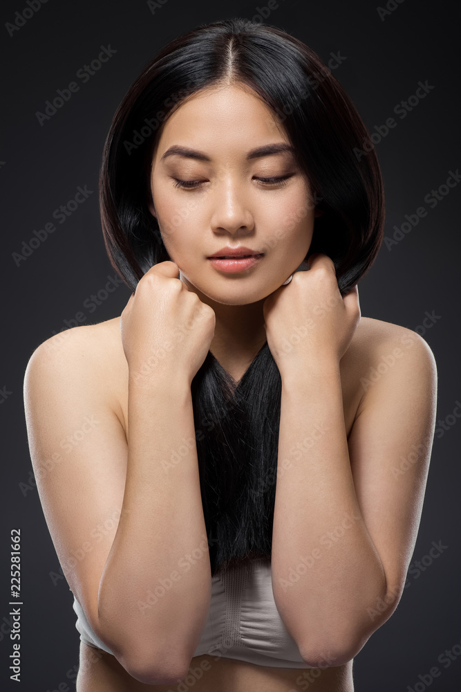 portrait of pretty asian woman with healthy and strong hair isolated on black portrait of pretty asian woman with healthy and strong hair isolated on black