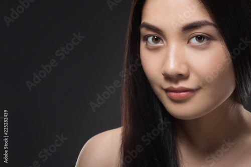 portrait of pretty asian woman with healthy and strong hair isolated on black