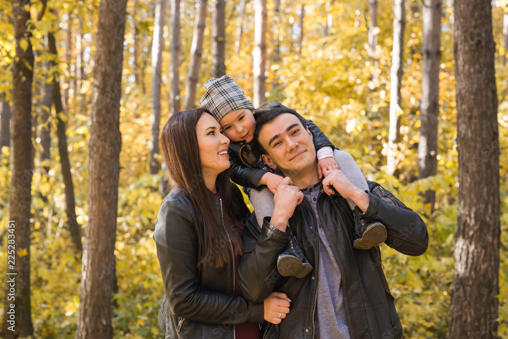 People, family and leisure concept - family having fun standing in autumn park People, family and leisure concept - family having fun standing in autumn park