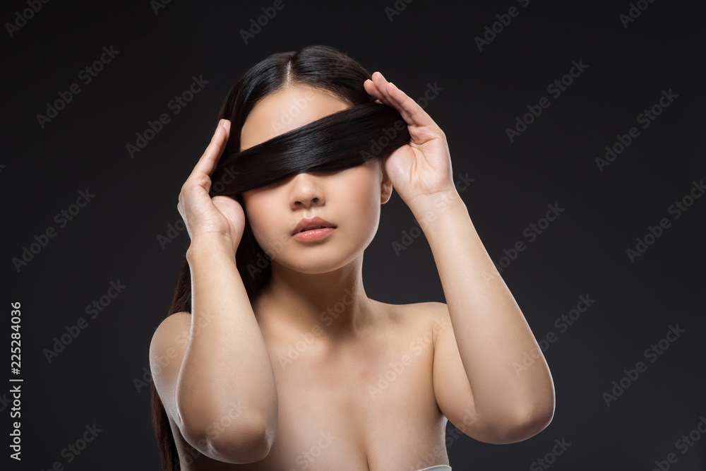 obscured view of asian woman with dark healthy hair isolated on black obscured view of asian woman with dark healthy hair isolated on black