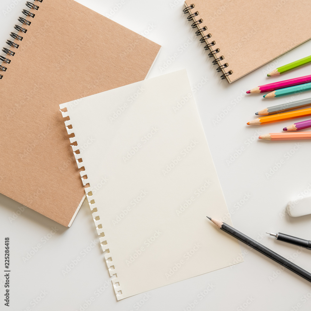 blank paper with spiral notebook, pencil, eraser and color pencil on white background. blank paper with spiral notebook, pencil, eraser and color pencil on white background.