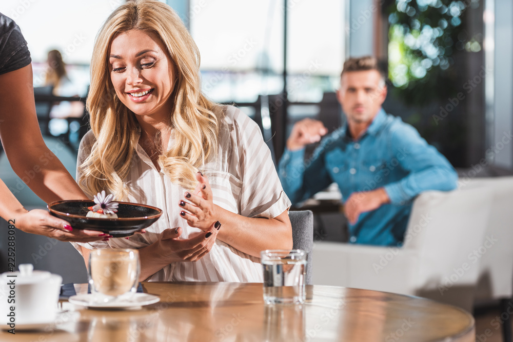 surprised happy woman looking at dessert with flower in cafe surprised happy woman looking at dessert with flower in cafe