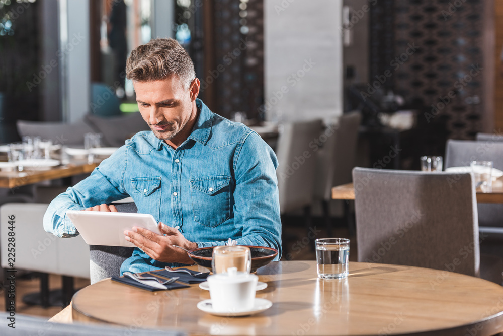 handsome man using tablet in cafe handsome man using tablet in cafe