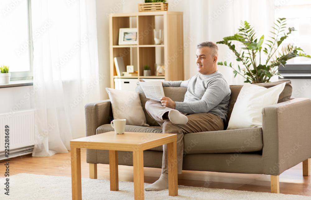 leisure, information, people and mass media concept - man reading newspaper at home leisure, information, people and mass media concept - man reading newspaper at home