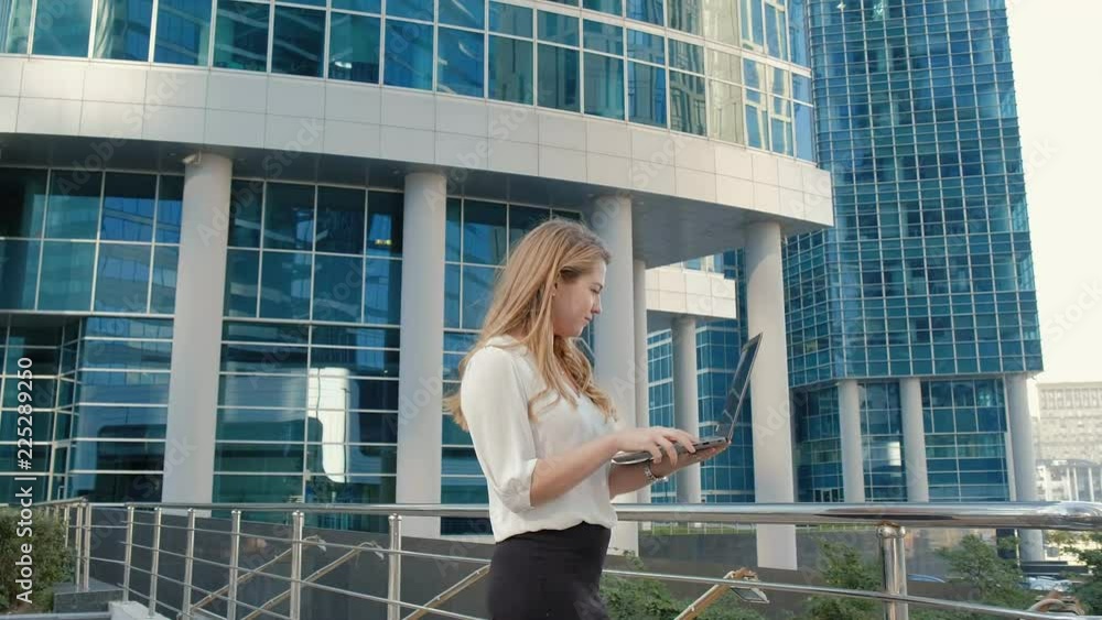 Young businesswoman working on laptop in city park business center Young businesswoman working on laptop in city park business center