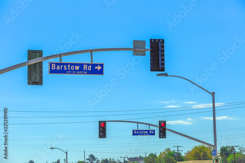 Red lights along Main Street or Route 66 in Barstow, California in San Bernardino County, Mojave Desert. Barstow Rd Sign in the blue sky.