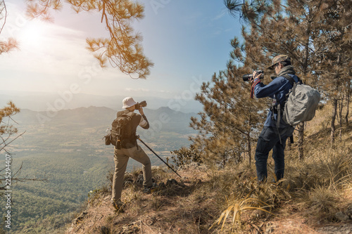 Fototapeta Naklejka Na Ścianę i Meble -  Photographer with camera in hand on top of mountain.