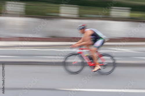 Blurred silhouettes of bicyclist on a blurred city background