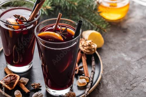 Hot mulled wine with spices, apple and orange on chrictmas background. Copy space.