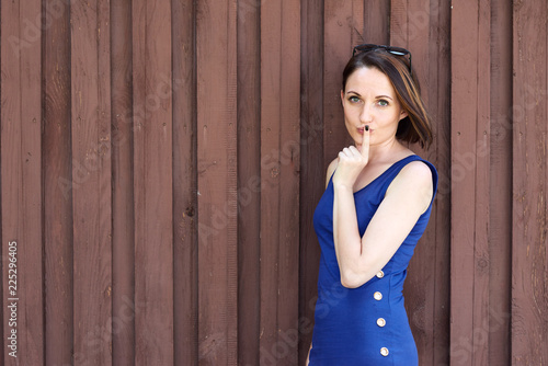 young girl posing on red brown wooden background, blue long dress