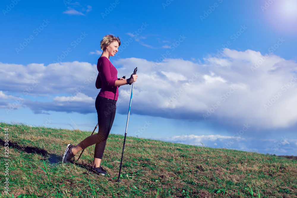 Nordic walking, exercise, adventure, hiking concept -a woman hiking in the nature