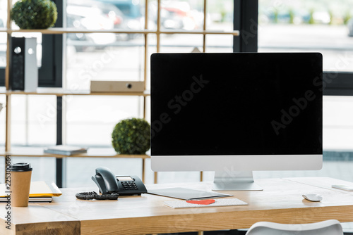 close up view of workplace with blank computer screen in office