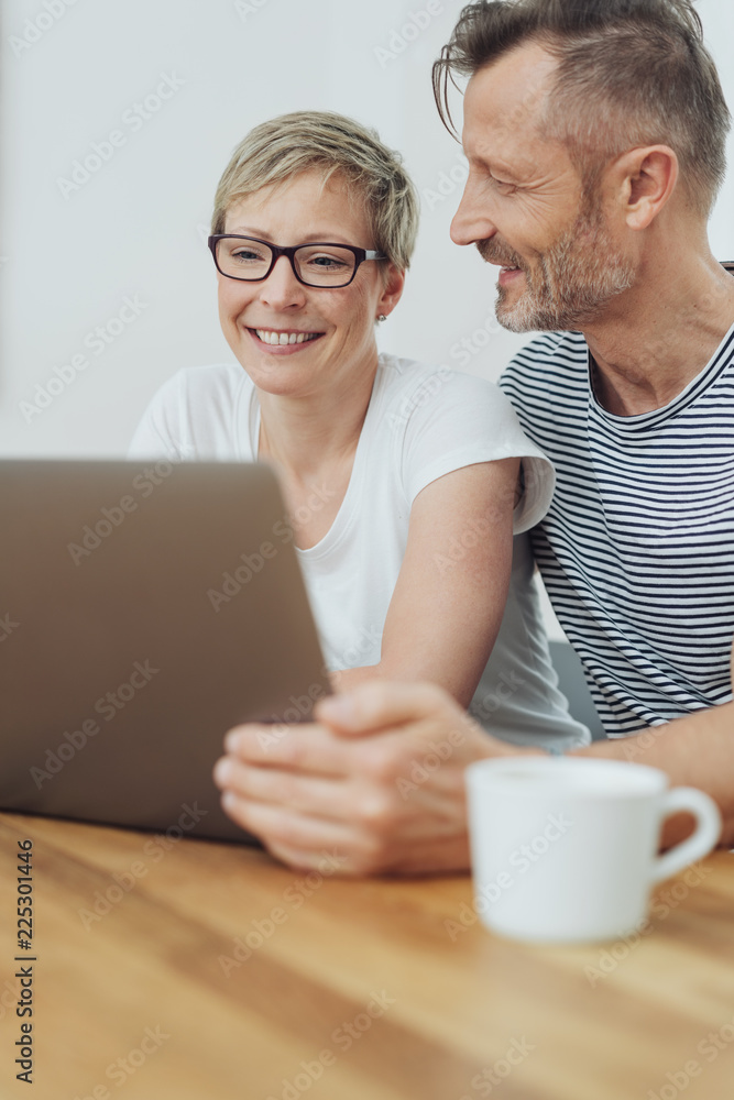 Woman beaming happily as she browses the internet Woman beaming happily as she browses the internet