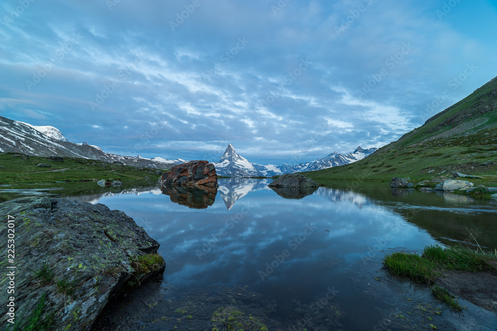 Blue hour shot of the Matterhorn (Monte Cervino, Mont Cervin) pyramid and Stellisee lake. Early morning view of majestic mountain landscape.