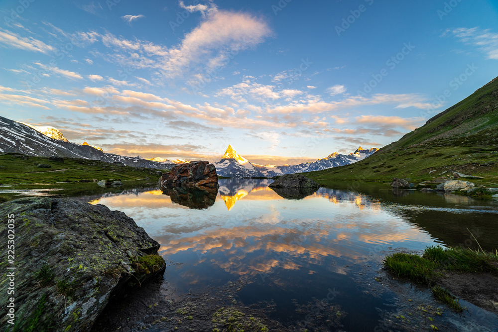 Obraz premium Morning shot of the golden Matterhorn (Monte Cervino, Mont Cervin) pyramid and blue Stellisee lake. Sunrise view of majestic mountain landscape. Valais Alps, Zermatt, Switzerland, Europe.