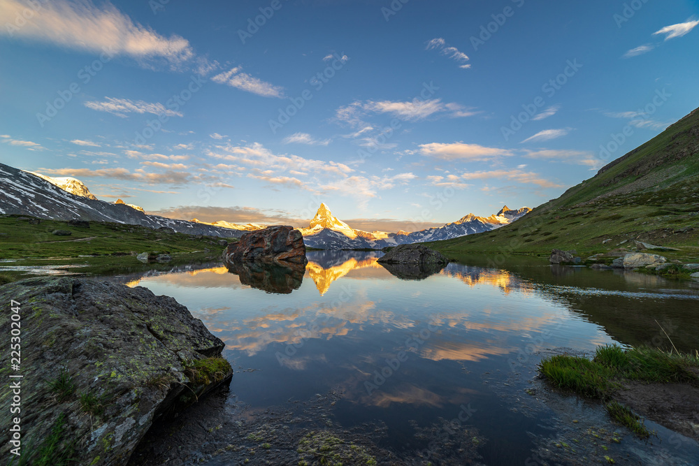 Obraz premium Morning shot of the golden Matterhorn (Monte Cervino, Mont Cervin) pyramid and blue Stellisee lake. Sunrise view of majestic mountain landscape. Valais Alps, Zermatt, Switzerland, Europe.