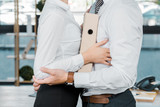 cropped shot of business coworkers with folder flirting in office