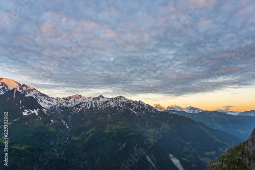 Scenic view of beautiful Swiss Alps mountains. Dramatic early morning scene in high mountains with first light. Blue hour sunrise with pink and blue tones  Switzerland.