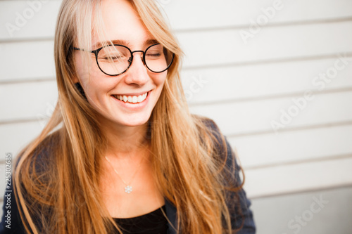 Beautiful blond girl with glasses for vision smiling and looking at the camera.