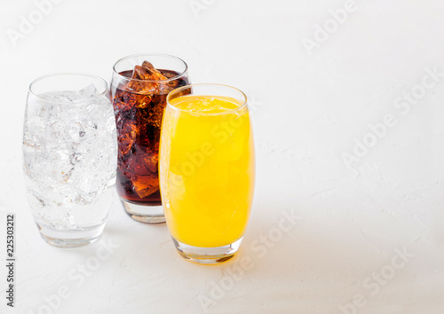 Foto Glasses of soda drink with ice cubes and bubbles on stone kitchen table background