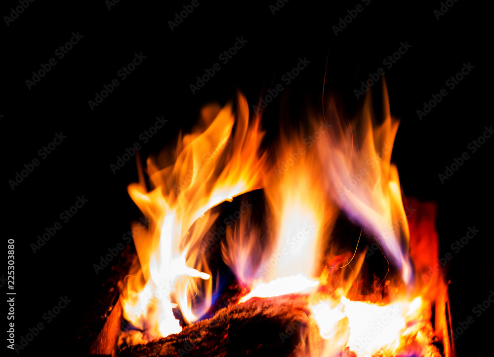 Bright burning firewood in the brazier, hot flame on a dark background, fire, sparks. Bright burning firewood in the brazier, hot flame on a dark background, fire, sparks.