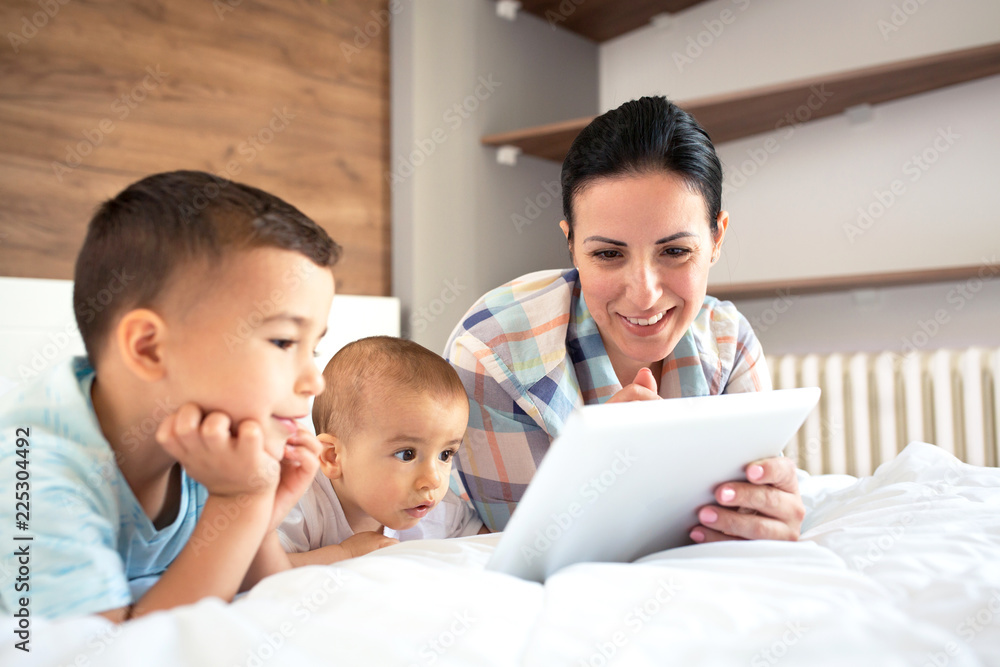 Caring mother showing tablet to her children Caring mother showing tablet to her children