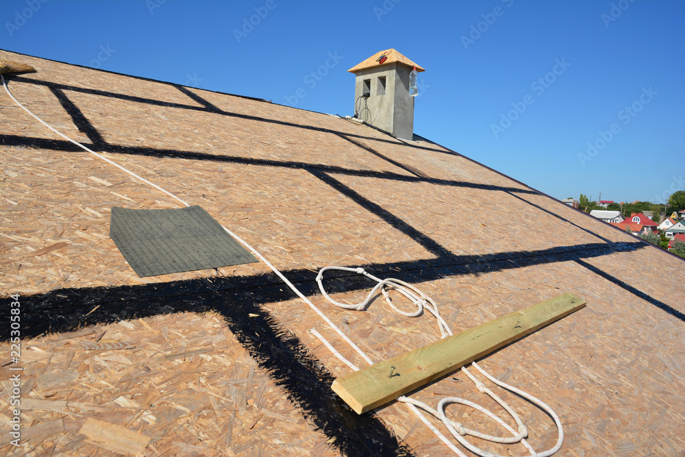 Roofing preparation asphalt shingles installing on house construction  wooden roof with bitumen spray and protection rope, safety kit. Roofing  construction. Stock Photo