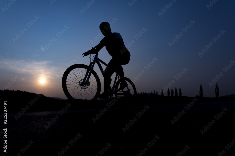 Silhouette of boy on the bike. Young cyclist is jumping on his bike during sunset. Silhouette of boy on the bike. Young cyclist is jumping on his bike during sunset.