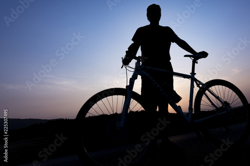 Silhouette of boy on the bike. Young cyclist is jumping on his bike during sunset.