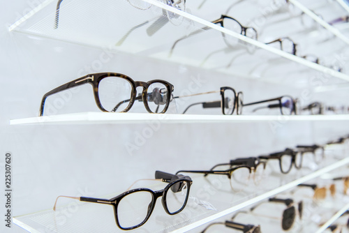 selective focus of white shelves with trendy glasses in ophthalmic shop photo