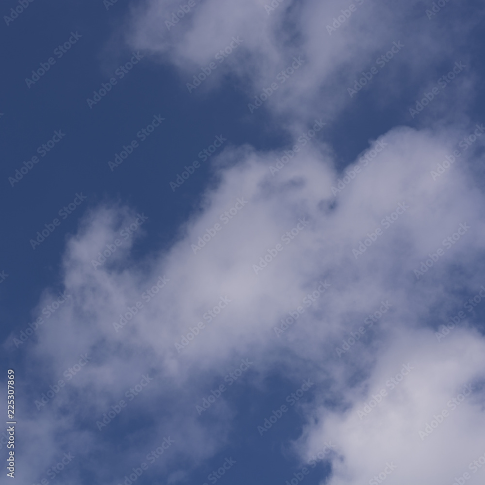 A view of the sky. A dark blue sky with white clouds.