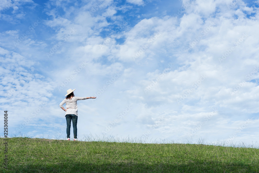 Woman standing on the mountain and point to beautiful sky. Woman standing on the mountain and point to beautiful sky.