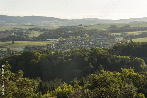 Morning view of the city in the valley in a fine mist lit by the rising sun.