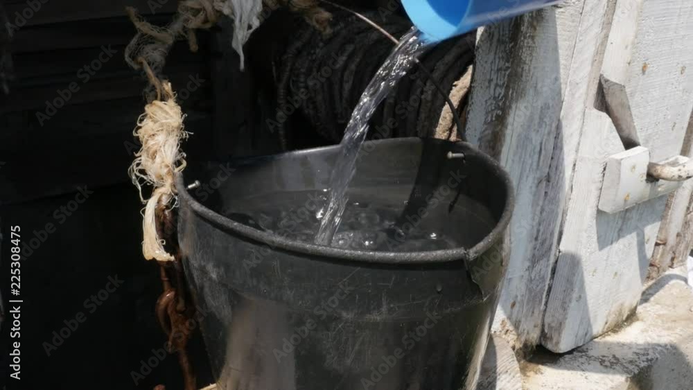 Emptying plastic cup in water well bucket slow-mo footage Emptying plastic cup in water well bucket slow-mo footage