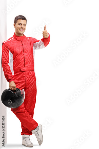 Racer leaning against a wall and holding his thumb up