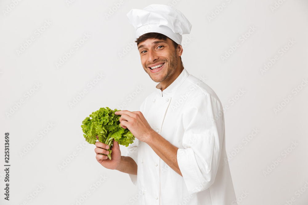Happy young chef isolated over white background holding salad. Happy young chef isolated over white background holding salad.