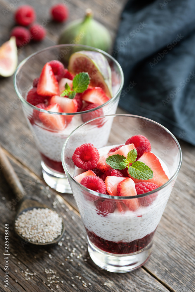Chia pudding with strawberries in glass on wooden background, selective focus. Vegan meal, dieting, healthy eating concept Chia pudding with strawberries in glass on wooden background, selective focus. Vegan meal, dieting, healthy eating concept