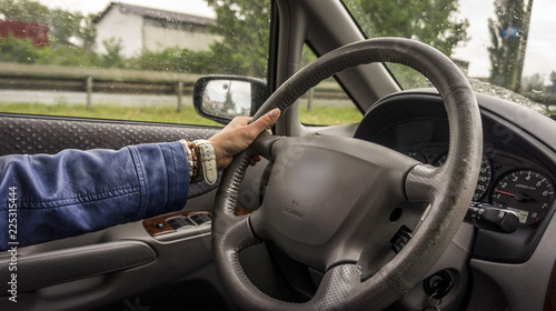 woman driving a car with one hand on the wheel. car interior and driver's hand.