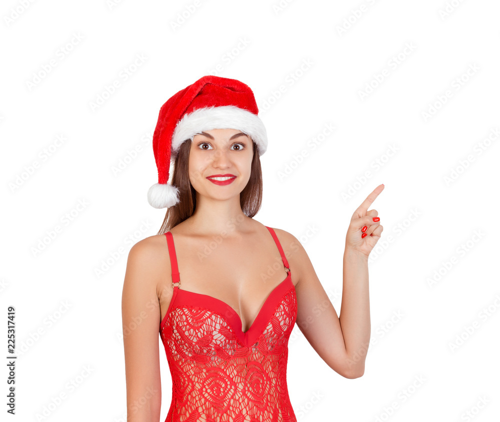 Sexy smiling girl in swimsuit christmas hat demonstrate invisible product finger. Recommend advertising concept. emotional woman in red santa claus hat isolated on white background Sexy smiling girl in swimsuit christmas hat demonstrate invisible product finger. Recommend advertising concept. emotional woman in red santa claus hat isolated on white background