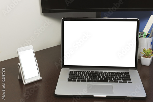 Desk Laptop and mobile with blank text space screen in office on wood table. Laptop mock-up conceptual workspace image.