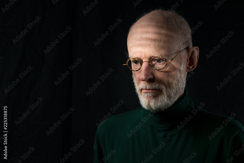 Obraz premium portrait of sad senior man looking down on black background
