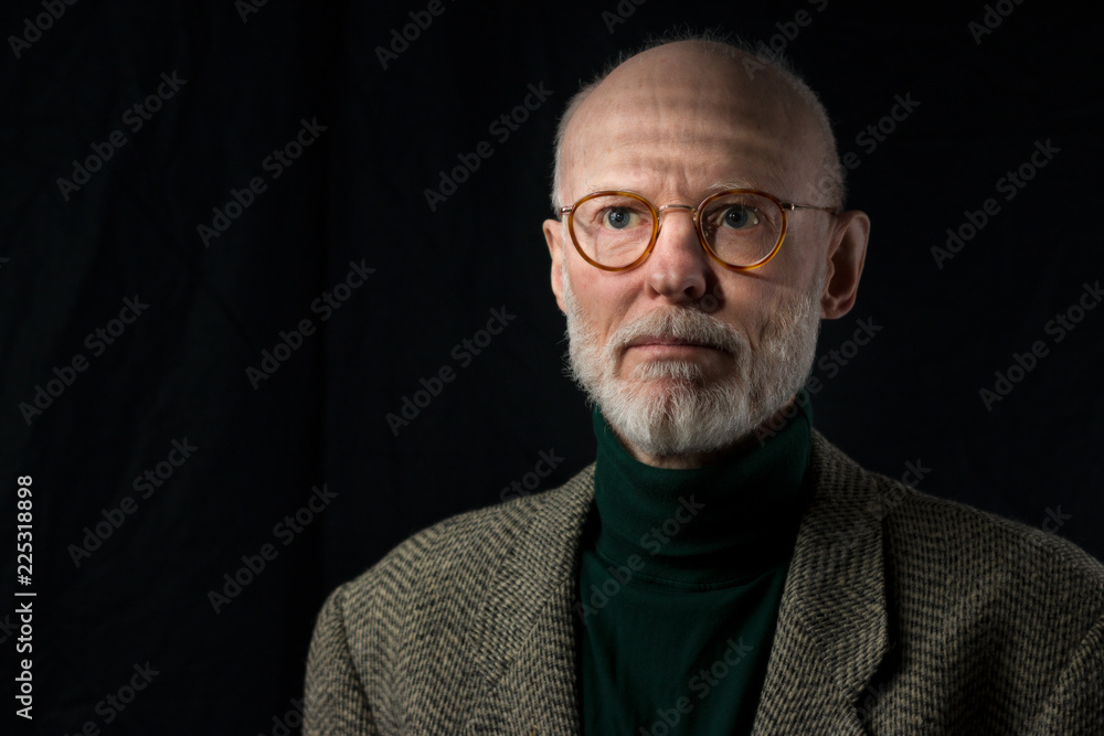 portrait of serious senior business man looking into the distance on black background portrait of serious senior business man looking into the distance on black background