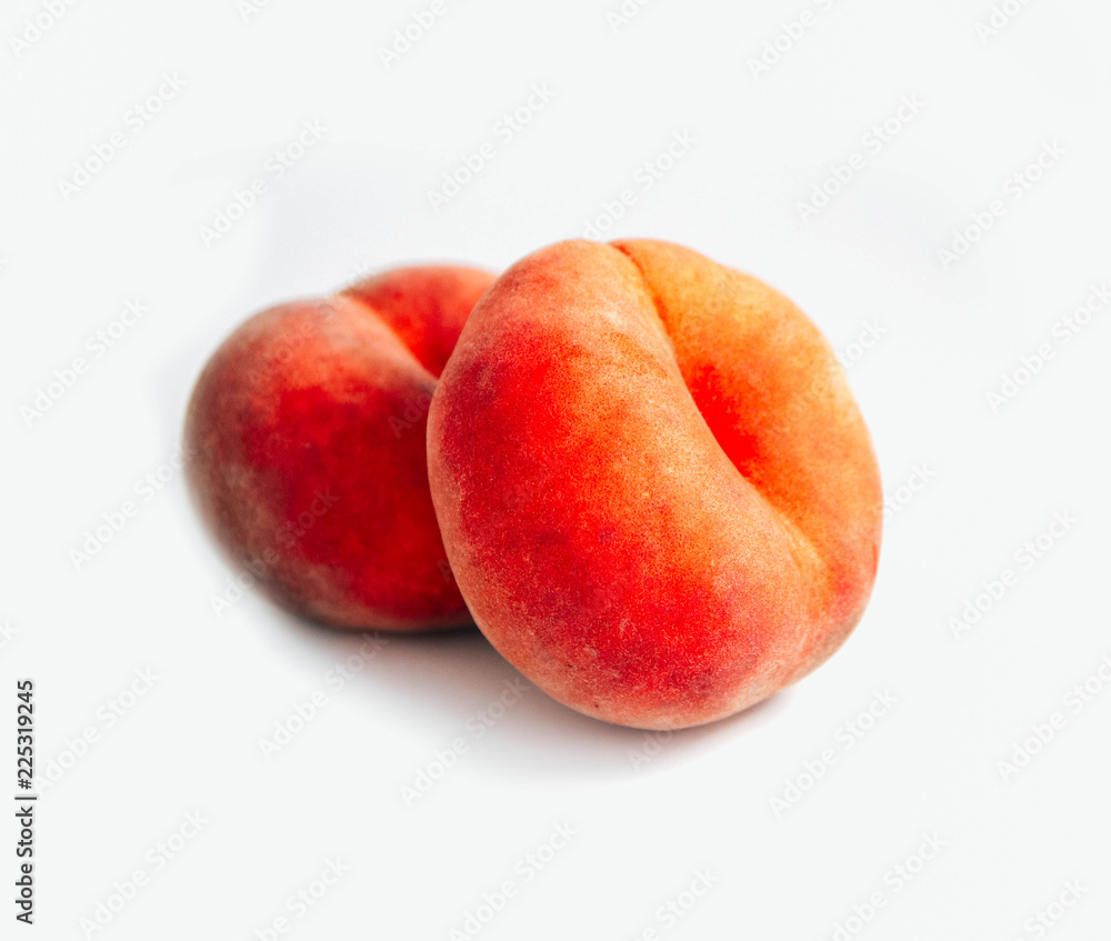 Saturn Peach isolated on white background. Flat peaches, two doughnut peaches in a pile. Saturn Peach isolated on white background. Flat peaches, two doughnut peaches in a pile.