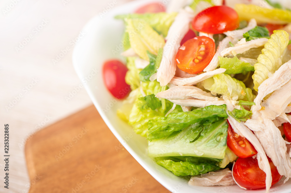 Fresh and delicious homemade chicken salad with tomatoes and pomelos in wooden background, concept of healthy and diet, top view, copy space