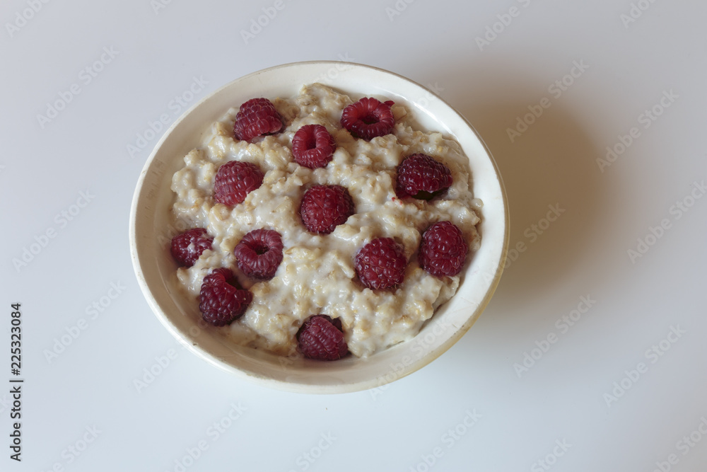 Hot oatmeal porridge with cream and fresh raspberries. Healthy breakfast concepts. Hot oatmeal porridge with cream and fresh raspberries. Healthy breakfast concepts.